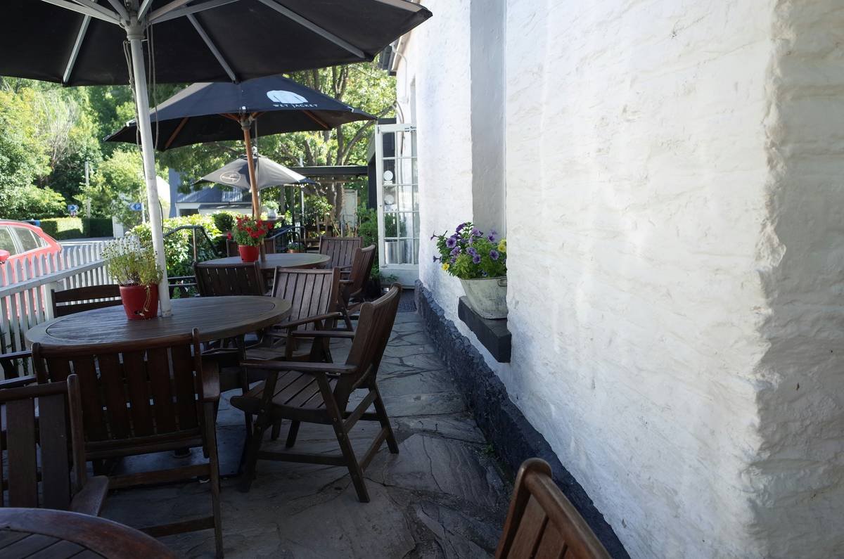Side-by-side comparison: freestanding umbrella tipping over vs. stable integrated canopy bed on patio