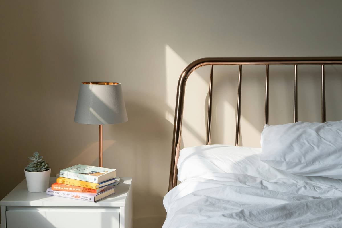 Small bedroom with one nightstand on side of bed and floating shelf on opposite side for balance